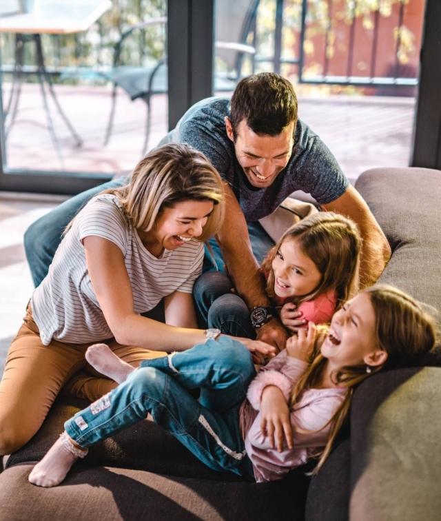 Family laughing on a couch